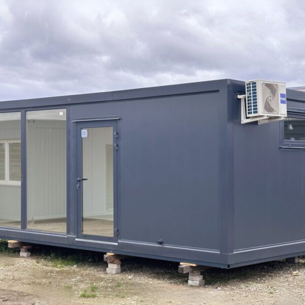 Pavilhão comercial construído a partir de um contentor marítimo de 3x7m com grandes montras, ar condicionado, casas de banho, estrutura de base e plataforma elevada.